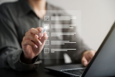 Frau vor einem Laptop, die an einer digitalen Checkliste arbeitet